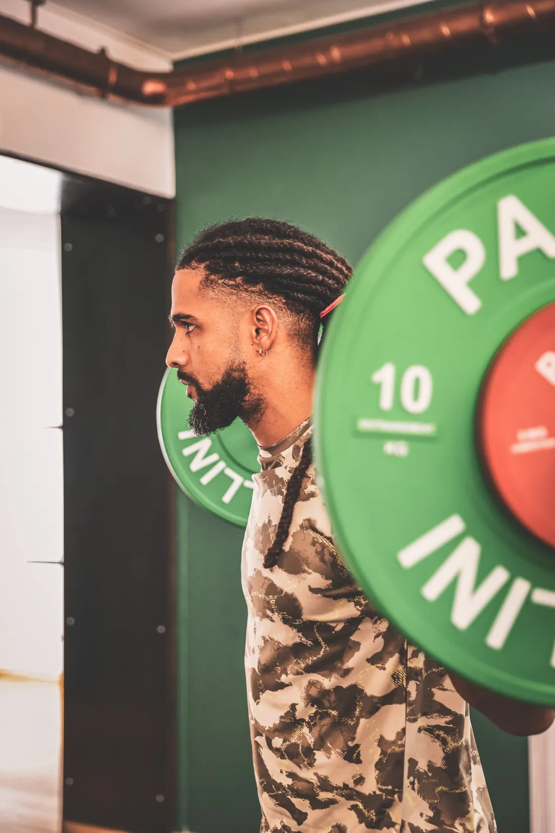 Le coach Strong Spine charge une barre de squat sur le plateau training